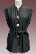 A sleeveless black linen tunic top with a high collar, decorative flower-shaped buttons, a matching fabric tie belt