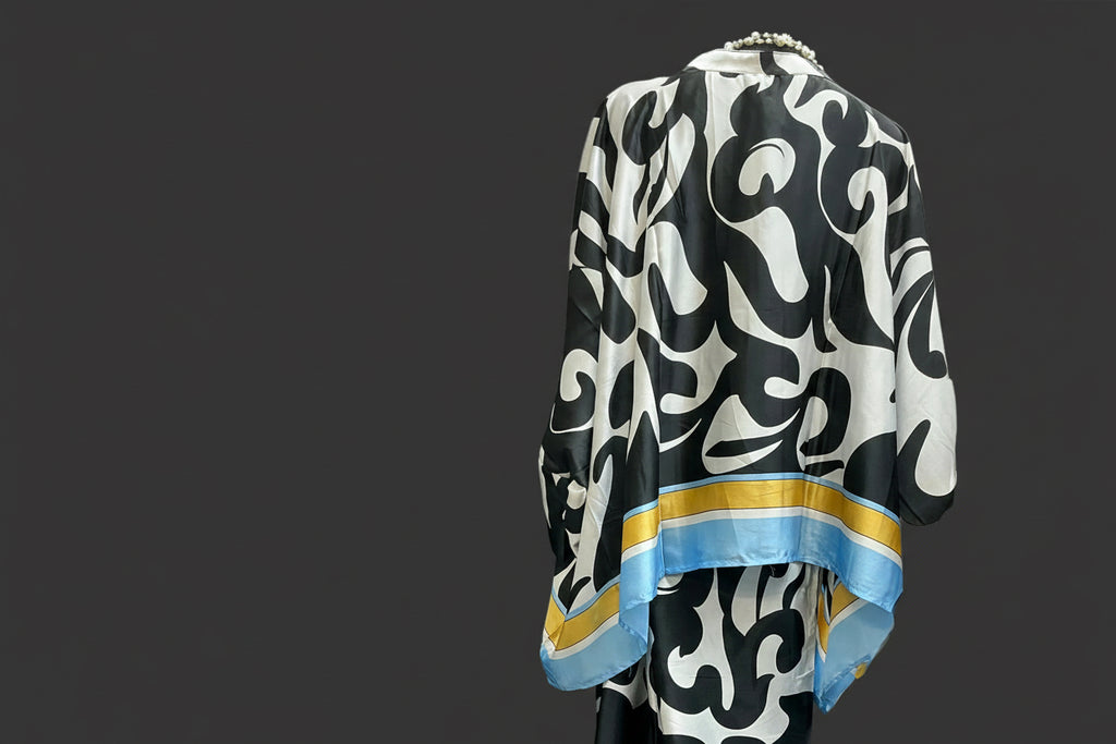 Back of black and white patterned garment with blue and gold accents