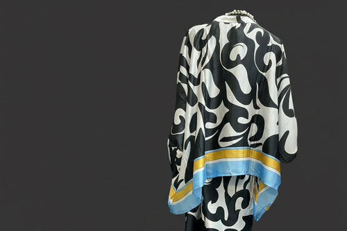 Back of black and white patterned garment with blue and gold accents