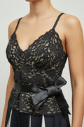 Black lace camisole top with underwire cups, thin shoulder straps, a matching black satin waist belt with a bow