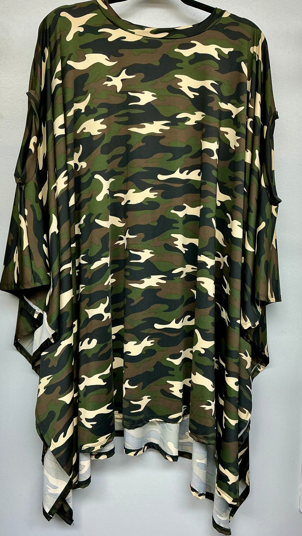 Camouflage-patterned dress on a hanger against a white background