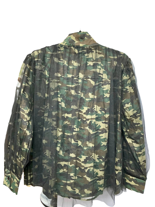Back view of camouflage-patterned shirt with a white wall background
