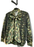 Camouflage shirt with black mesh overlay with a large bow on a hanger against a white background