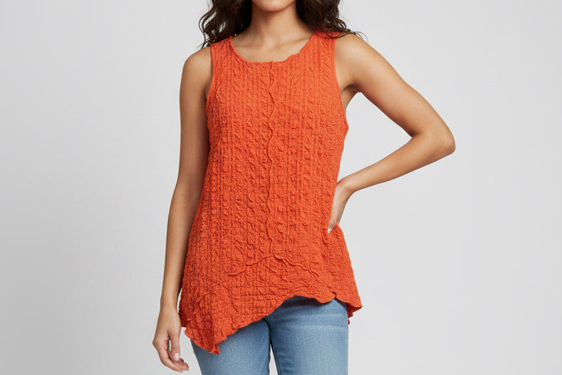 An orange sleeveless top with a ruffled, crinkled pattern and an asymmetrical handkerchief hem on model