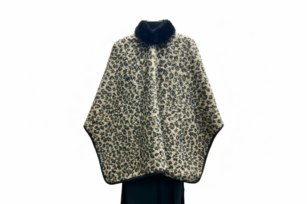 Leopard print cape with black fur trim on a hanger.