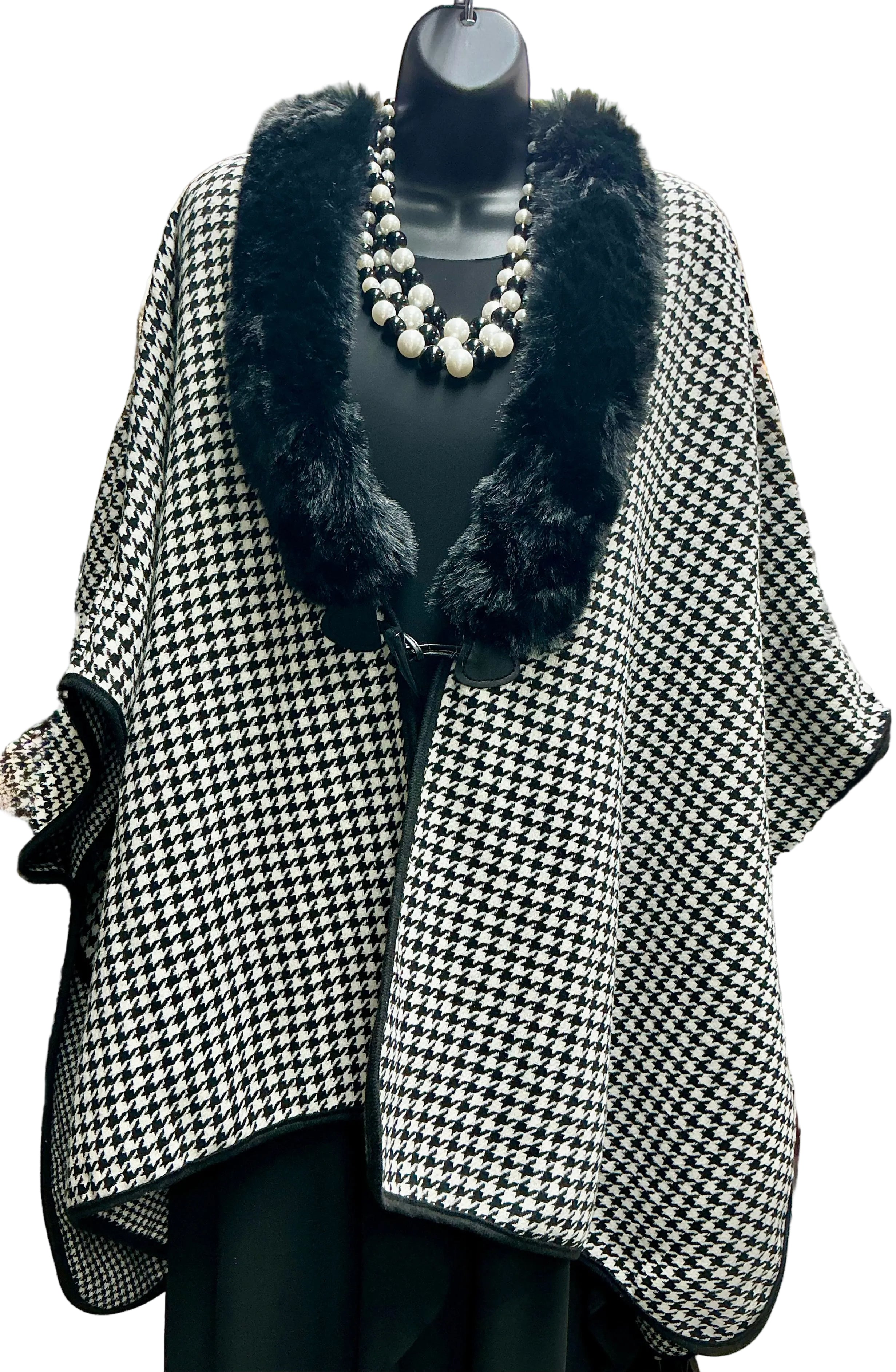 Houndstooth patterned coat with black fur trim on a mannequin.