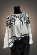 A black and white graphic print long-sleeve top on a mannequin in a retail store setting.